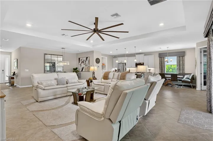 Living area featuring hanging lights, a tray ceiling, and a ceiling fan