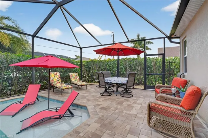 View of patio featuring a lanai, a sunroom, and outdoor dining area