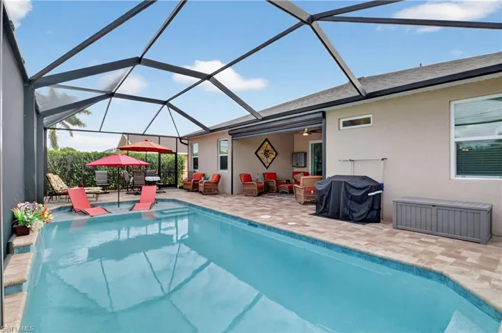 Outdoor pool featuring area for grilling, a lanai, a sunroom, a patio, and an outdoor lounge area