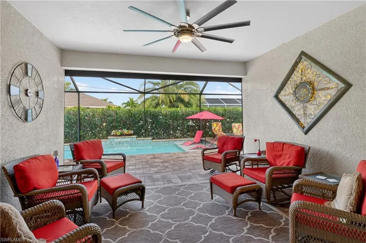 View of patio with outdoor furniture, a sunroom, glass enclosure, an outdoor pool, and ceiling fan