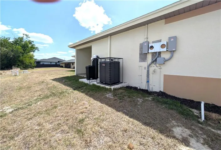 View of side of home featuring stucco siding and a lawn