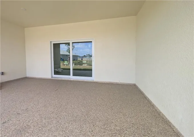 Empty room featuring speckled floor and baseboards