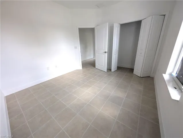 Unfurnished bedroom with a closet and light tile patterned floors