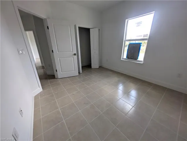 Unfurnished bedroom featuring light tile patterned flooring and a closet