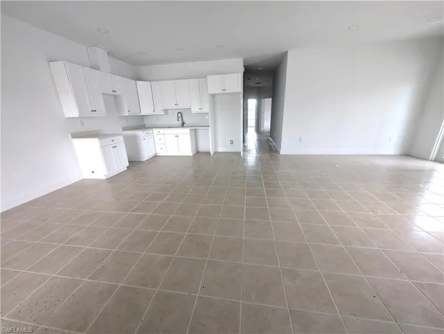 Unfurnished living room with light tile patterned floors and recessed lighting