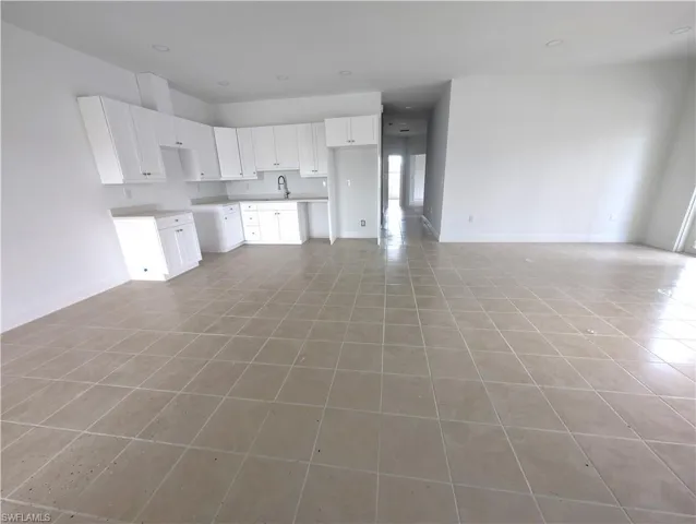 Unfurnished living room featuring light tile patterned floors and recessed lighting