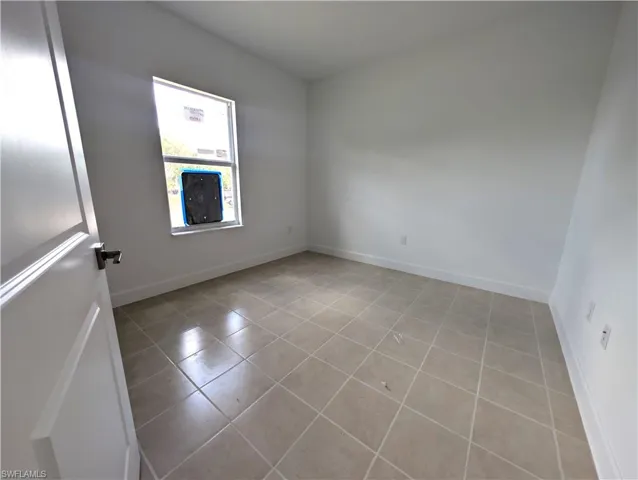 Unfurnished room with light tile patterned floors