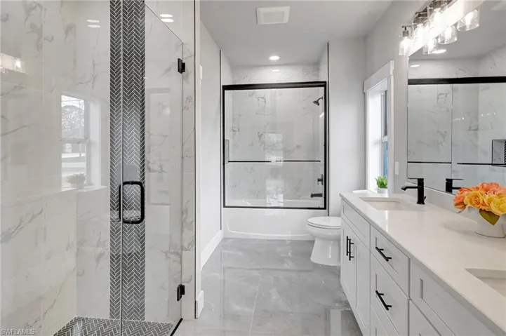 Full bathroom featuring vanity, combined bath / shower with glass door, and toilet