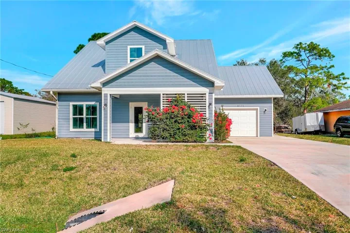View of front of property featuring a garage and a front lawn