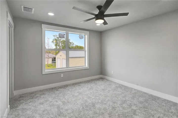 Spare room with ceiling fan and light colored carpet