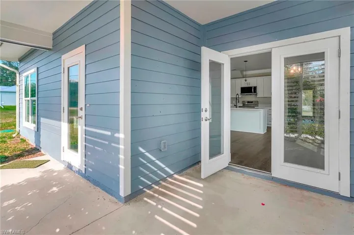 Entrance to property with an outdoor kitchen, sink, and a patio area