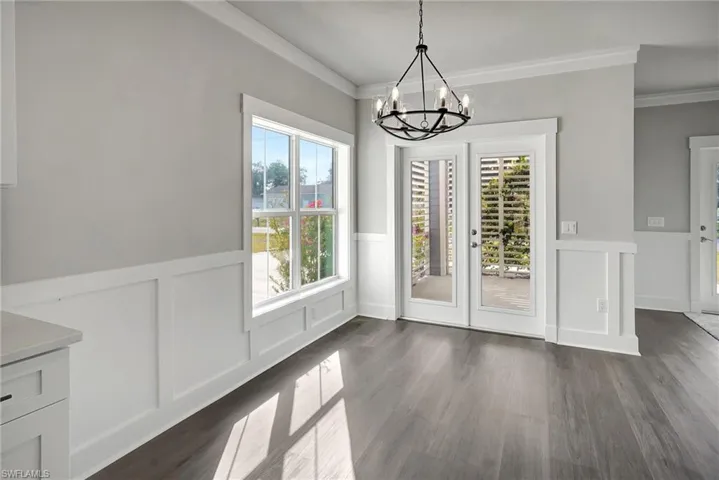 Unfurnished dining area featuring crown molding and dark hardwood / wood-style floors