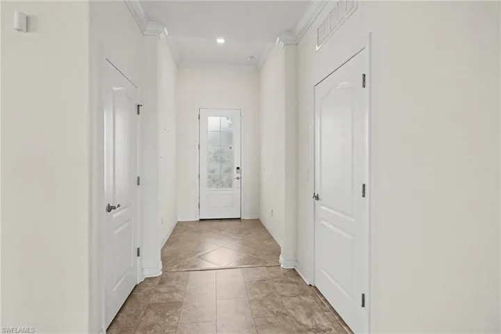 Hallway featuring recessed lighting, crown molding, and tiled flooring