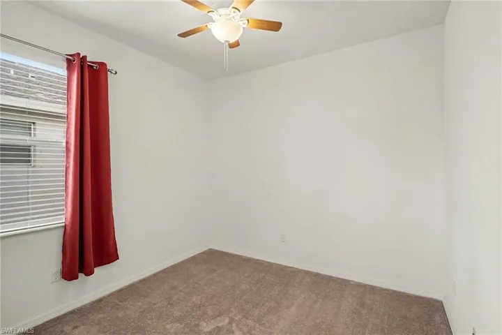 Neutral wall color, window with blinds, and ceiling fan with integrated lighting