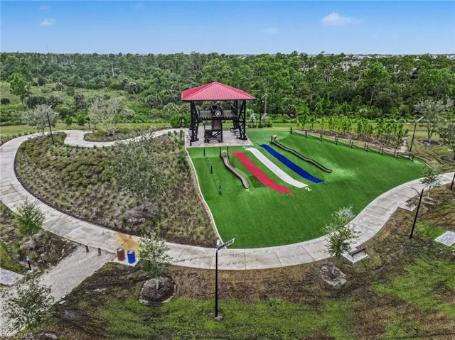 Recreational area featuring a covered observation tower, multiple turf slides, and winding paved pathways