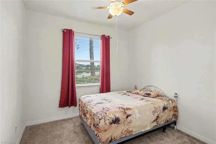 Carpeted flooring, a window with blinds, and a ceiling fan with integrated lighting
