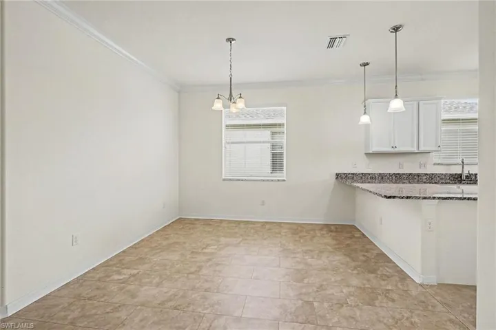 Dining area with tile flooring and crown molding
