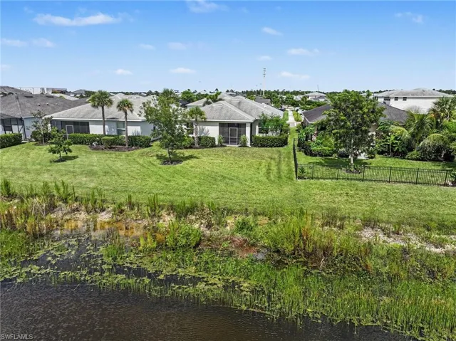 Waterfront backyard featuring lush green lawn and mature trees