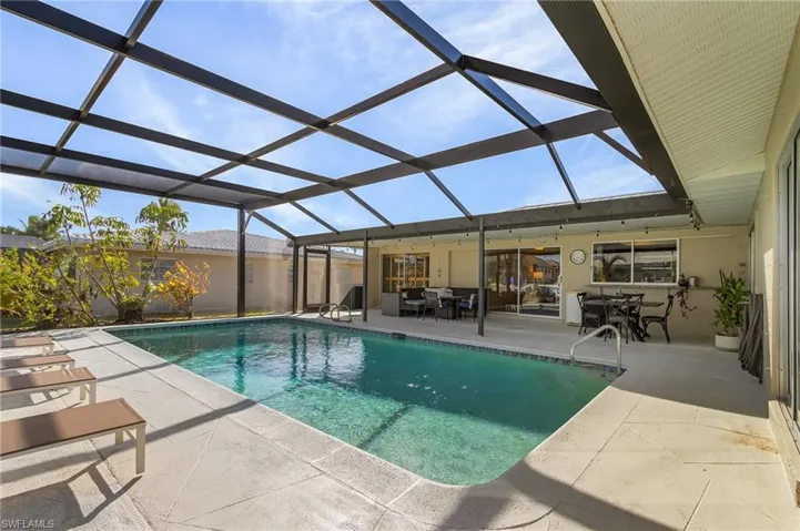 View of swimming pool featuring a patio and a lanai