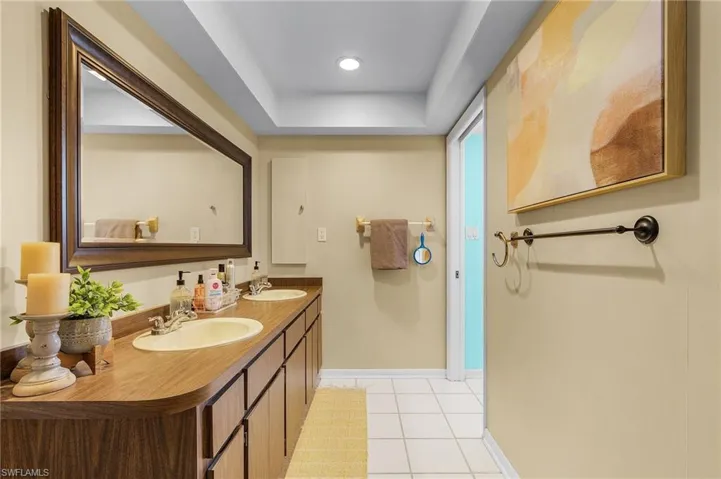 Bathroom featuring vanity, tile patterned floors, and a tray ceiling