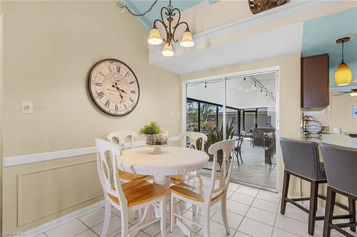 Dining room with ceiling fan with notable chandelier and light tile patterned floors