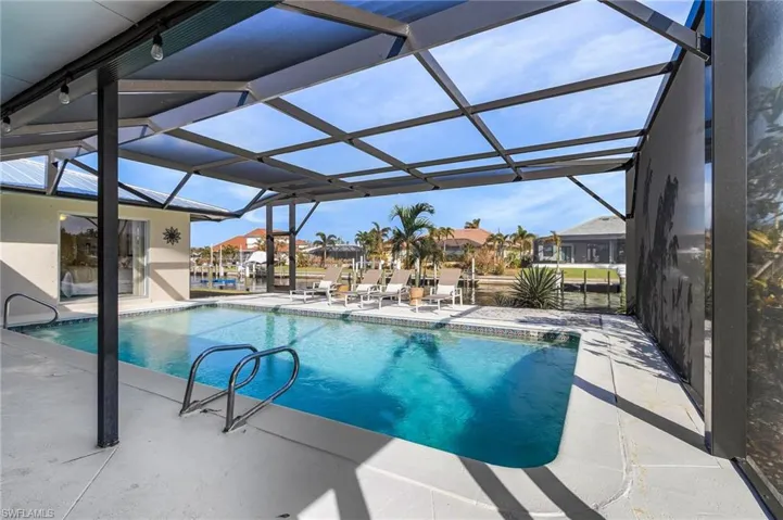 View of pool with a patio area and a lanai