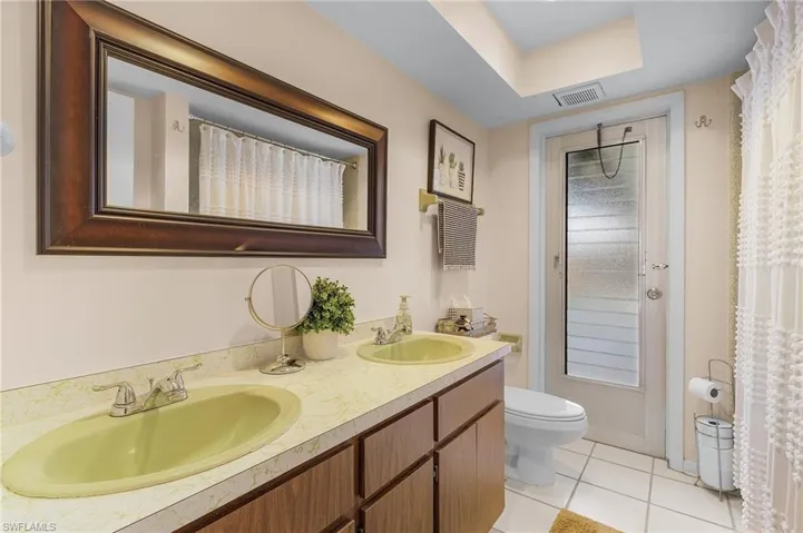 Bathroom with toilet, vanity, and tile patterned flooring