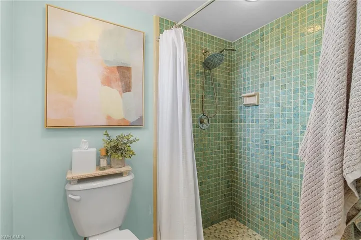 Bathroom featuring toilet and a shower with curtain