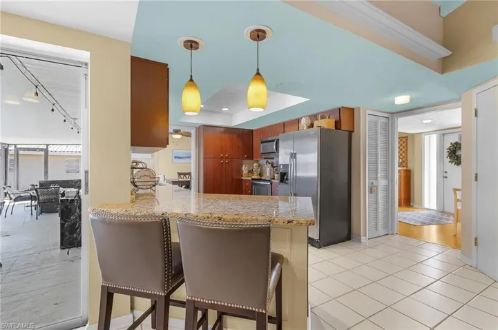 Kitchen with a breakfast bar area, appliances with stainless steel finishes, kitchen peninsula, and light wood-type flooring