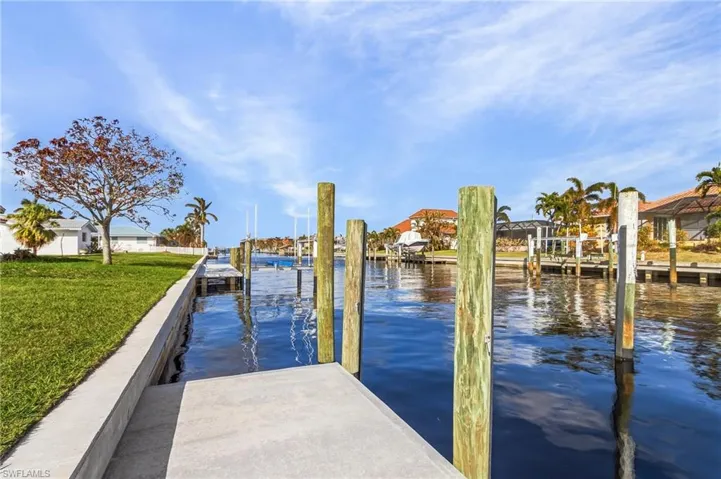 Dock area featuring a lawn and a water view
