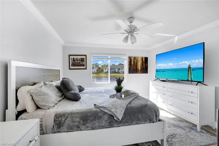 Bedroom featuring ceiling fan, light hardwood / wood-style floors, and ornamental molding