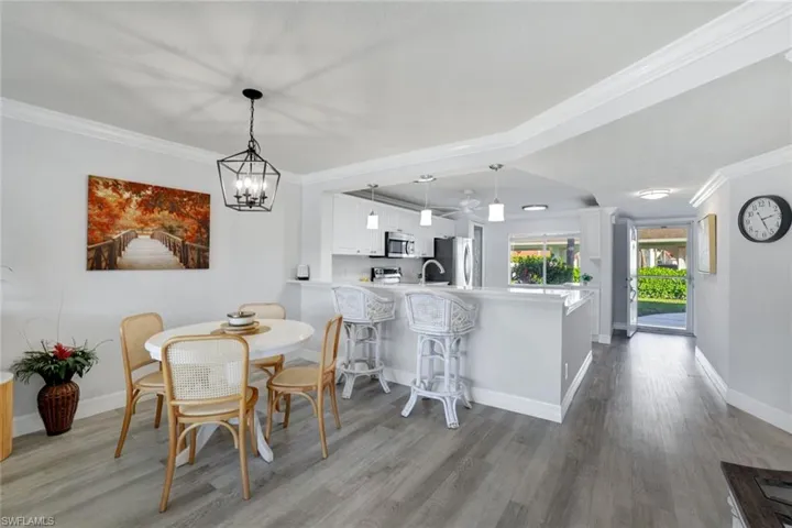 Dining space featuring crown molding, lCoretex vinyl flooring, and light fixture.