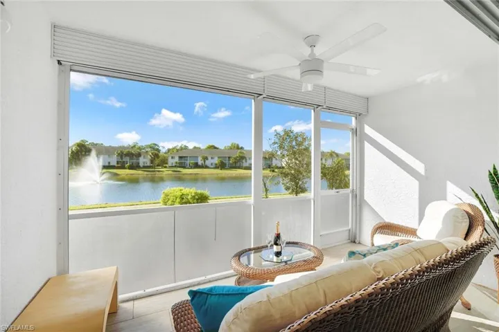 Sunroom / solarium featuring ceiling fan and a water view