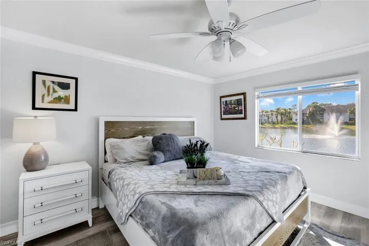 Primary bedroom featuring crown molding and water view with a water feature