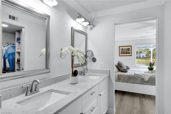 Bathroom with ceiling fan, vanity, Coretex vinyl flooring, and crown molding