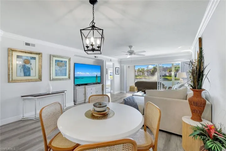 Dining space featuring crown molding, lCoretex vinyl flooring, and light fixture.