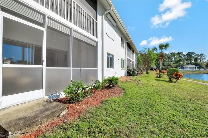 View of property exterior with a water view and a yard