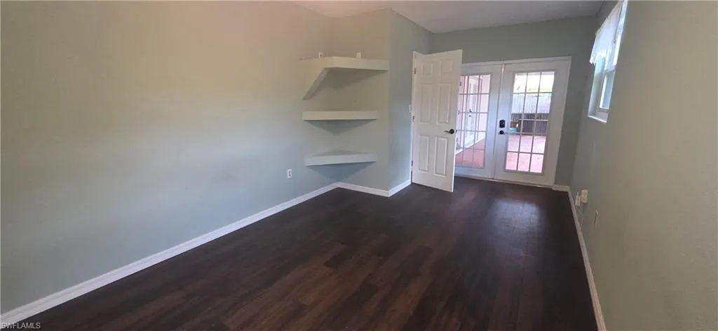 bedroom area featuring french doors and dark wood-style flooring