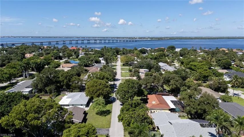 Aerial perspective of suburban area featuring a notable bridge and a nearby Caloosahatchee River