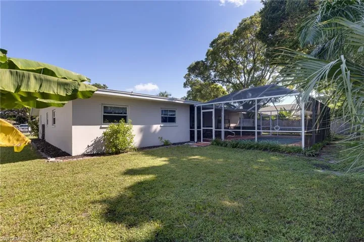 Rear view of house featuring a lanai and pool