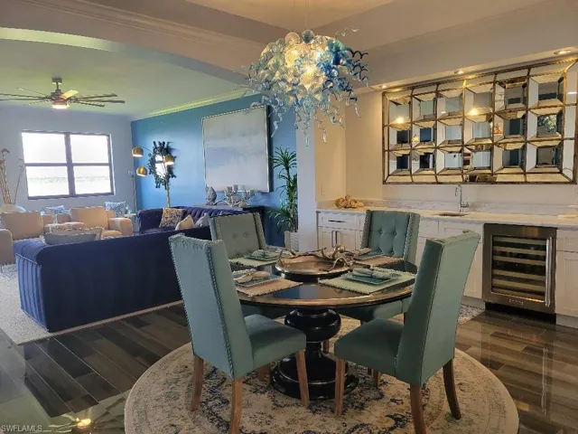 Dining space with crown molding, dark wood-type flooring, wine cooler, and ceiling fan