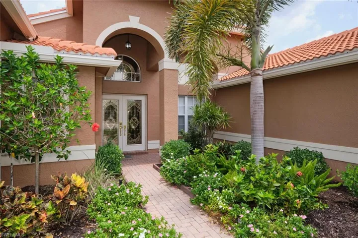 View of exterior entry with a tiled roof, french doors, and stucco siding