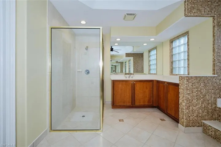 Bathroom with vanity, recessed lighting, a stall shower, light tile patterned floors, and a ceiling fan