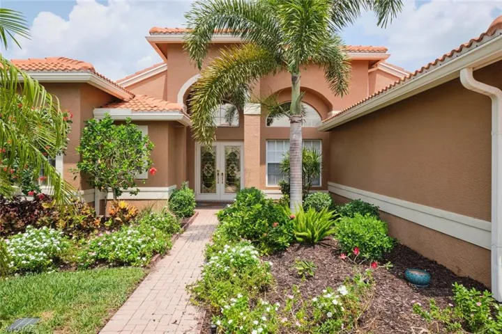 Property entrance with french doors, stucco siding, and a tiled roof
