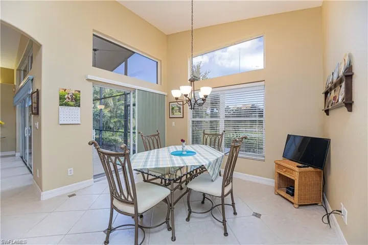 Dining area featuring a high ceiling, a chandelier, and light tile patterned flooring