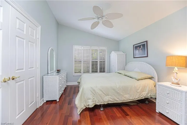 Bedroom with lofted ceiling, dark wood-type flooring, and ceiling fan