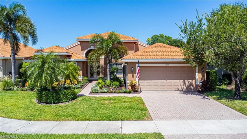 Mediterranean / spanish house featuring a garage, decorative driveway, stucco siding, a tile roof, and a front yard