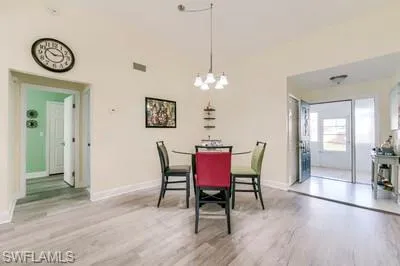 Dining space featuring light wood-style flooring and a chandelier