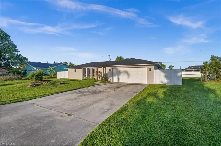 Ranch-style house featuring concrete driveway and an attached garage