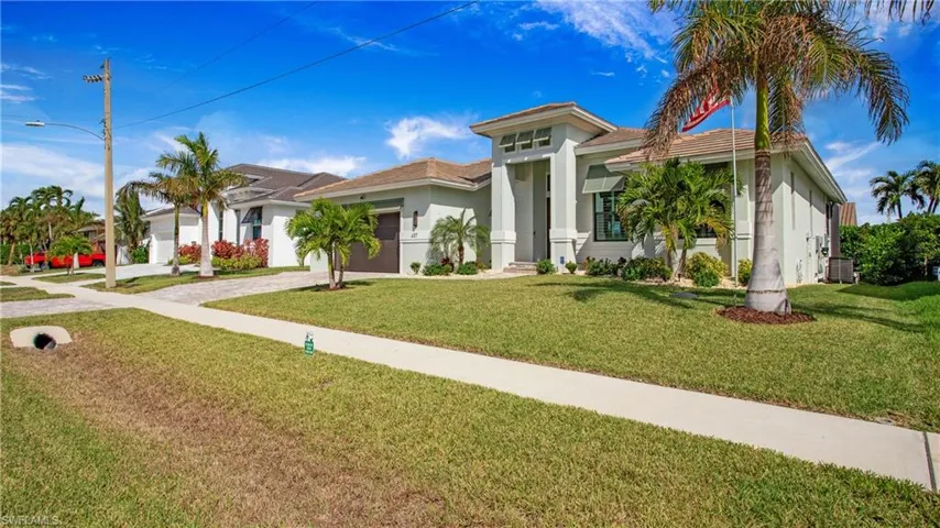 View of front facade featuring a garage and a front lawn
